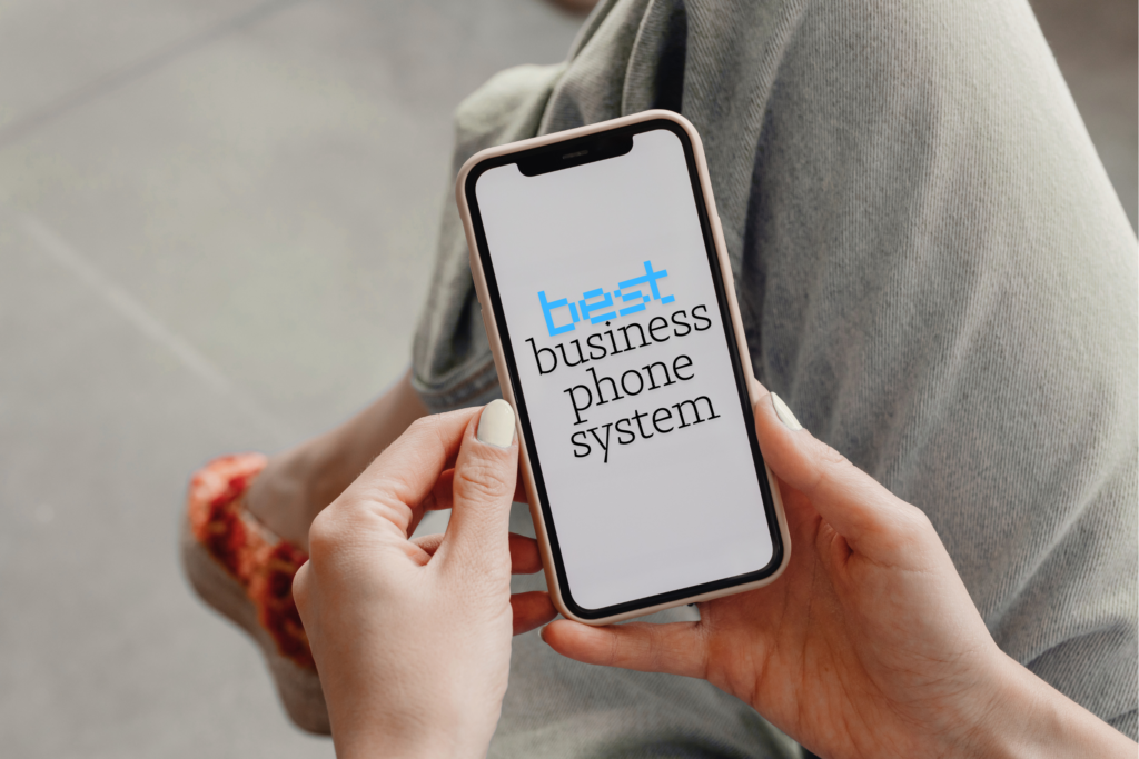 Photo showing the cell phone screen of a white woman sitting with leg crossed. The screen says Best business phone system.